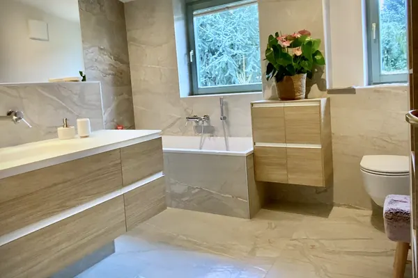 Saniertes Badezimmer mit Badewanne, Waschtisch und Wand-WC – Badsanierung, Kärnten